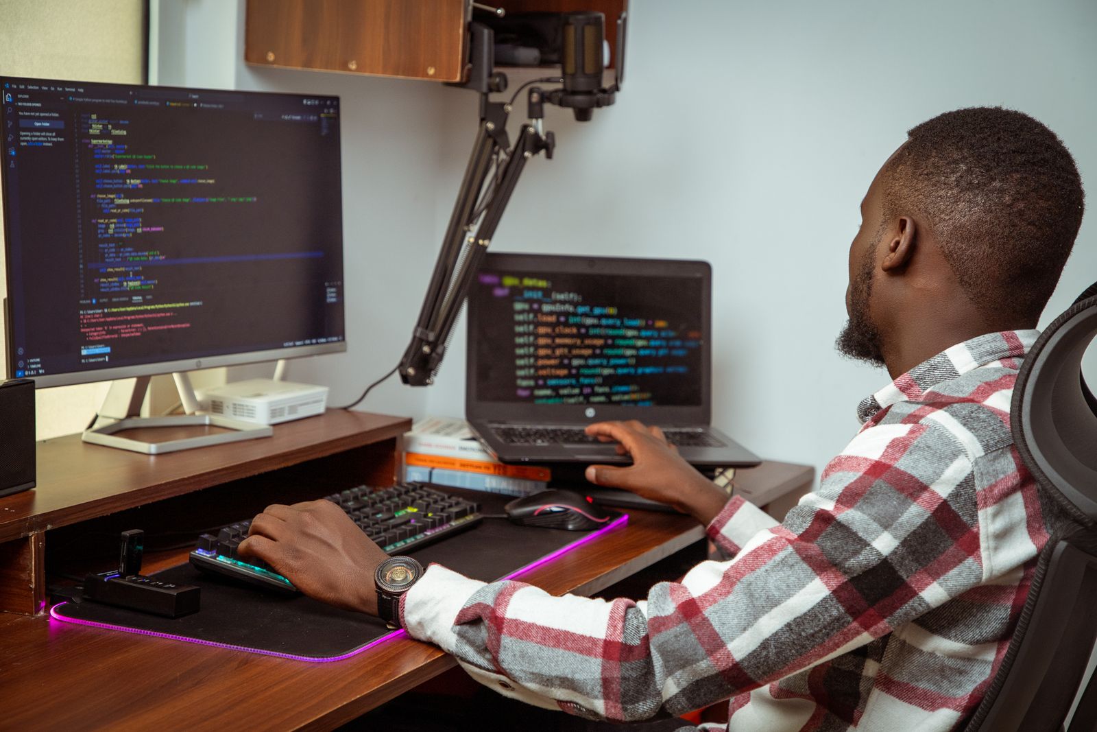 Software developer working across desktop and laptop displays